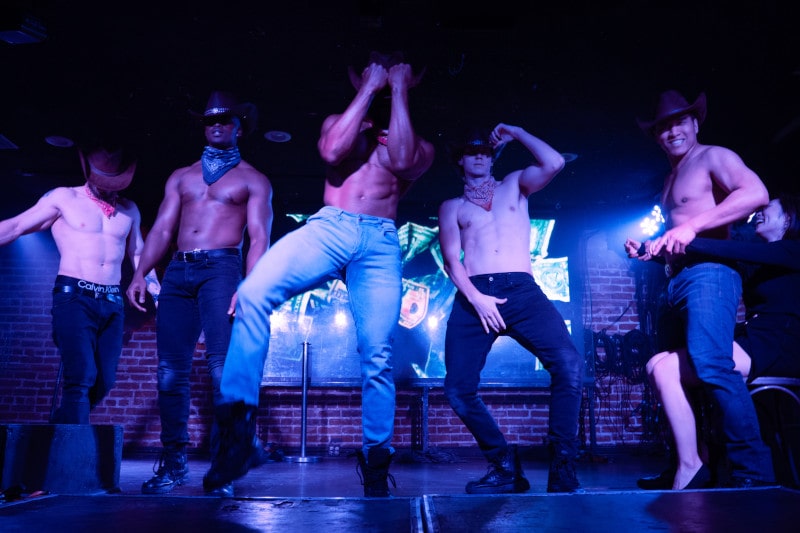 five topless cowboy male strippers on stage
