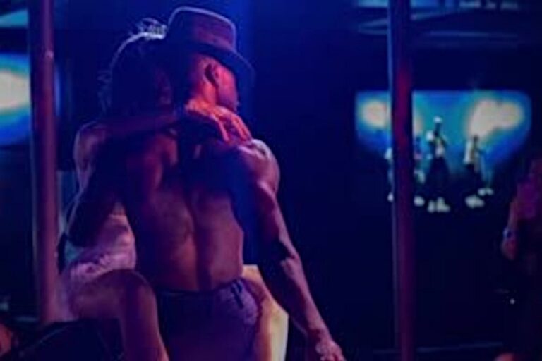 Instructor Terrance male strip act face backside view holding lady in arms